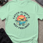 Catching Flights not Feelings T-Shirt in Mint Green, front view.