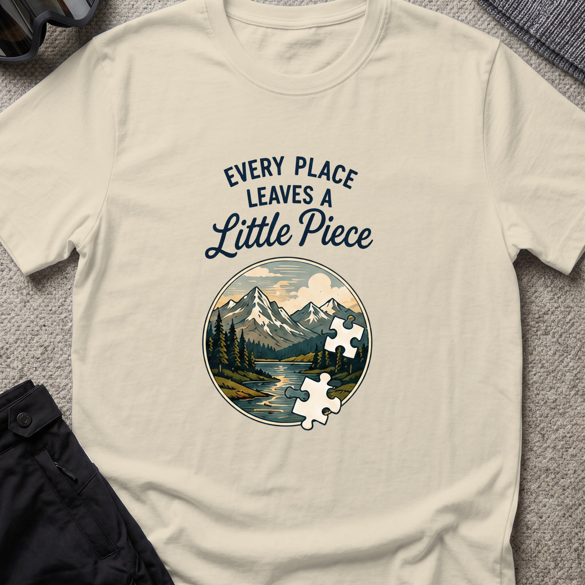 Every Place Leaves a Little Piece T-Shirt in Sand, front view.
