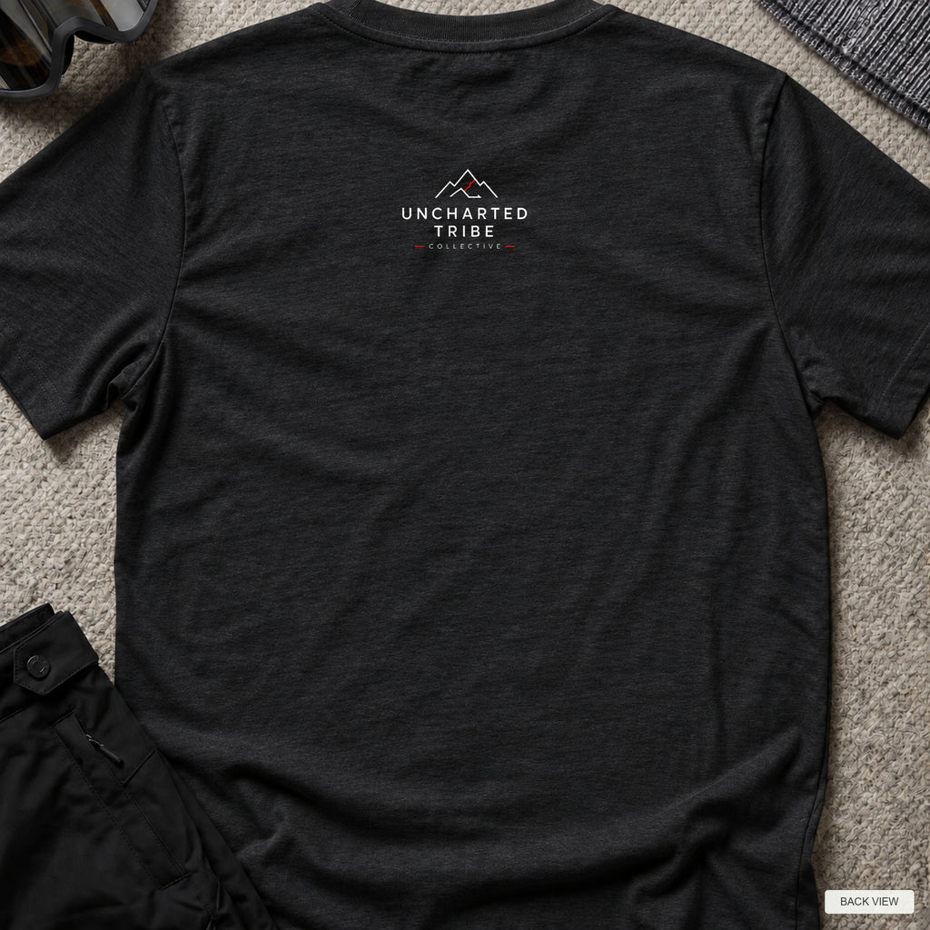 Uncharted Tribe Network — Cyber Tee in Black Heather, back view showing the small Uncharted Tribe Collective logo below the rear neckline on a flat-laid T-shirt.