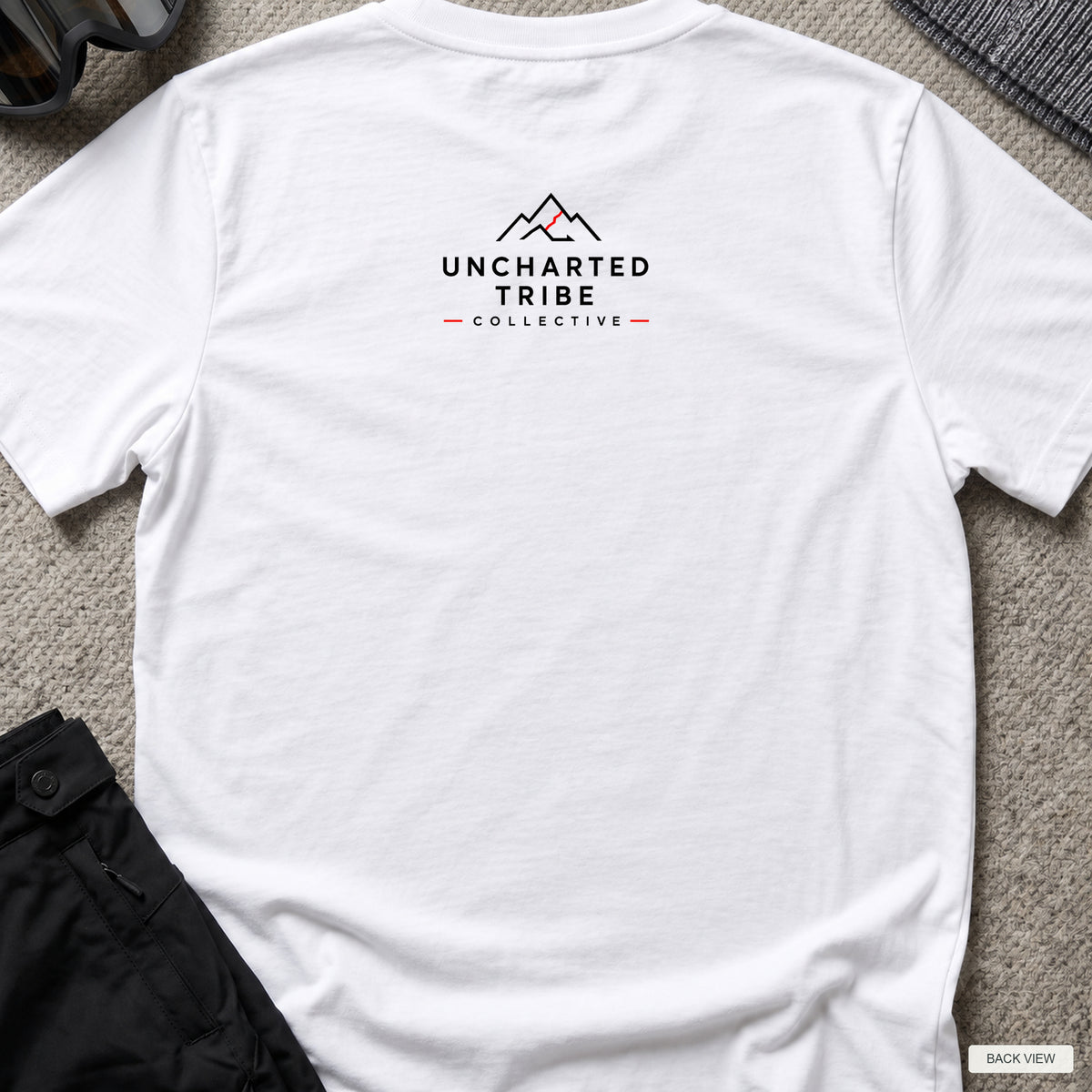 Floral Camera T-shirt in White, back view showing the small Uncharted Tribe Collective logo below the rear neckline.